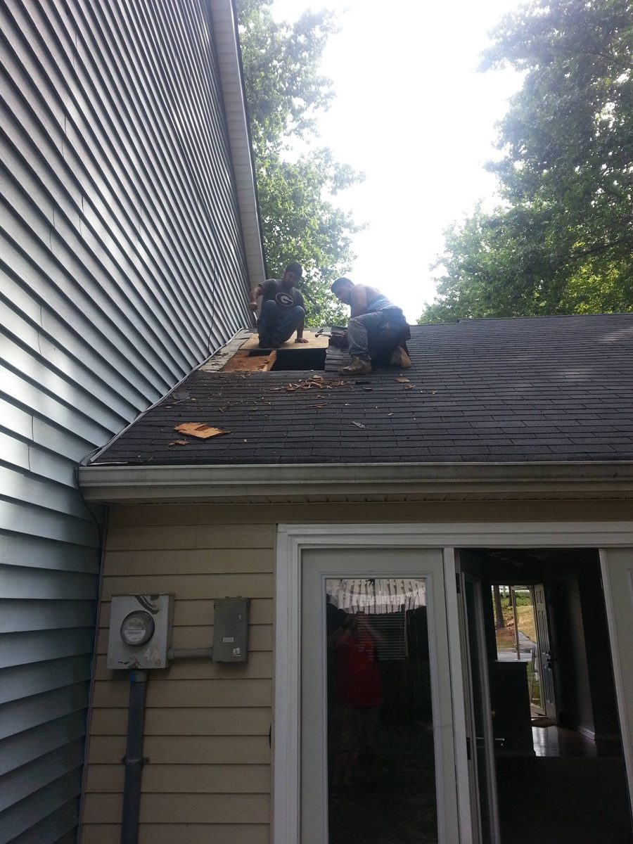 Before: the crew cutting out rotten roof decking over the back door