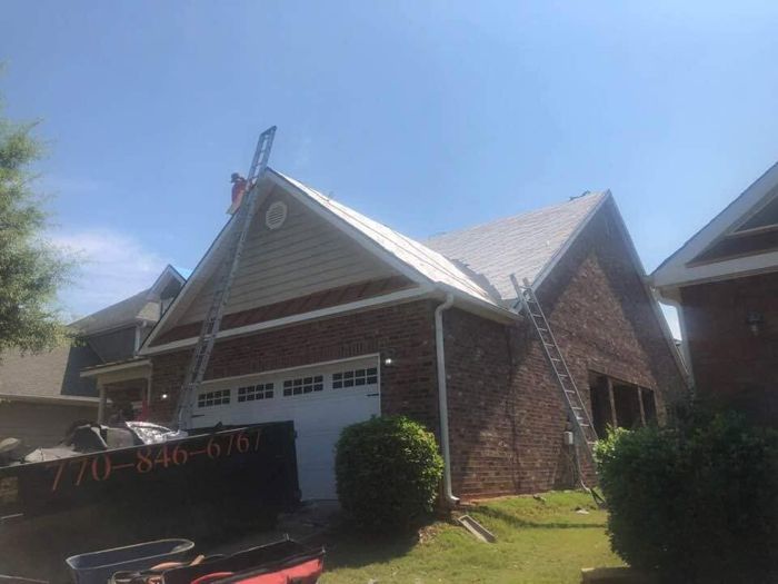 Roof replacement in progress on a brick two-story home